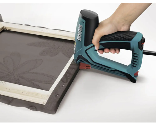 Eine Hand verwendet einen Elektrotacker, um Stoff auf einen Rahmen zu tackern