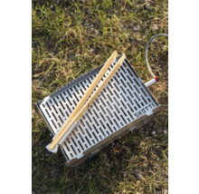 Edelstahlgrill mit Grillzange auf Gras