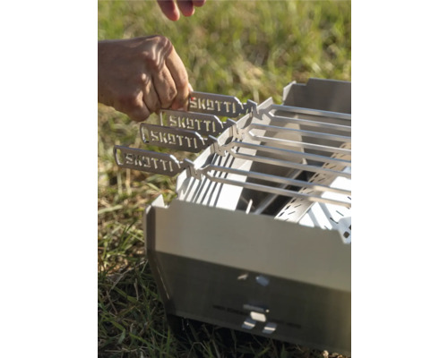 Grillspieße werden auf einen Grill gelegt