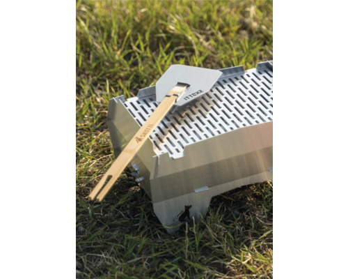Grill Skotti avec spatule à griller sur l''herbe