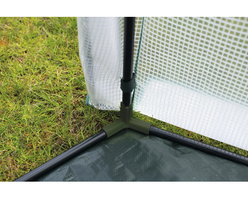 Gros plan d''une serre avec film plastique et structure verte sur l''herbe