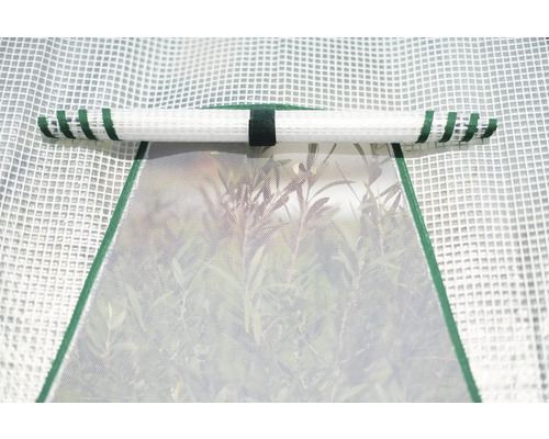 Vue détaillée d''une serre avec une fenêtre ouverte et un store enroulé.