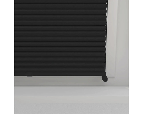 Gros plan d''un store plissé noir dans une fenêtre