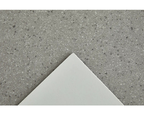 Gros plan d''un plan de travail avec une surface mouchetée et une plaque blanche