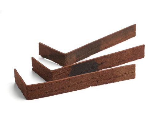 Drei rotbraune Klinkerriemchen Eckstücke auf einem weißen Hintergrund