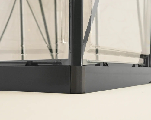 Vue détaillée d'une serre avec cadre et panneaux transparents.