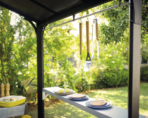 Grillszene im Freien mit Grillbesteck, Geschirr und Beilagen unter einem Grillpavillon.