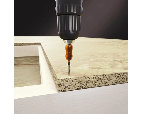 Schraube wird mit einem Akkuschrauber in eine Holzplatte geschraubt.