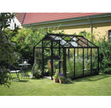Gewächshaus im Garten mit Tisch und Stühlen.