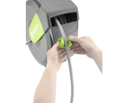 Une personne fixe un tuyau sur un enrouleur de tuyau GEKA