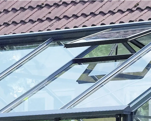 Vue détaillée d''une serre avec une fenêtre ouverte pour l''aération