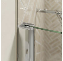 Gros plan d''une cabine de douche avec paroi en verre transparent et raccords chromés.
