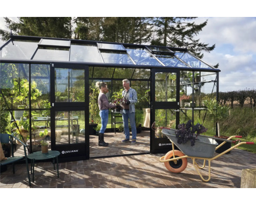 Serre avec deux personnes et une brouette dans le jardin.