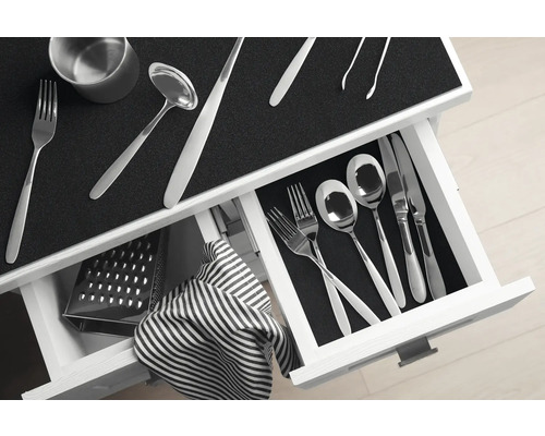 Geöffnete Schublade mit Besteck, Reibe und Geschirrtuch