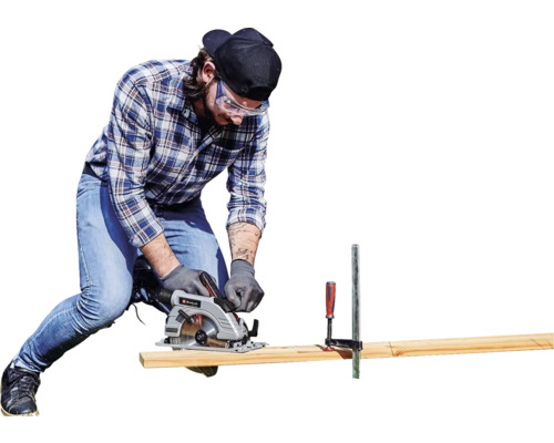 Mann sägt mit einer Handkreissäge ein Holzbrett, welches mit einer Schraubzwinge fixiert ist