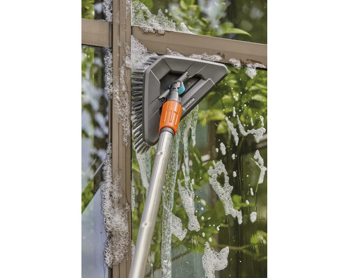 Nettoyage des vitres avec une brosse de lavage et un manche télescopique
