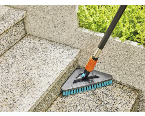 Balai à récurer Gardena avec manche télescopique utilisé sur un escalier en pierre
