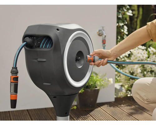 Gardena Schlauchbox mit Gartenschlauch und Anschluss an einen Wasserhahn im Aussenbereich