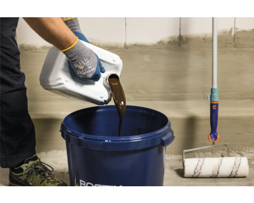 Eine Person gießt flüssige Abdichtung aus einem Behälter in einen Eimer, neben einer Farbwalze.