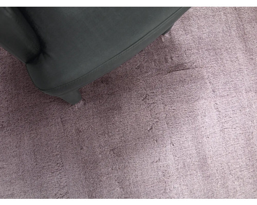 Nahaufnahme eines hochflorigen Teppichs neben einem Sessel