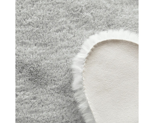 Vue détaillée d''un tapis rond gris clair à poils longs