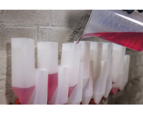 Gießkanne füllt Flüssigkeit in Dosierspender