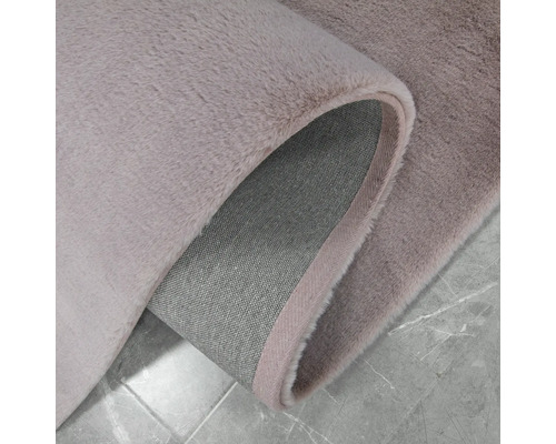 Vue détaillée d''un tapis à poils longs de couleur claire avec un envers en textile