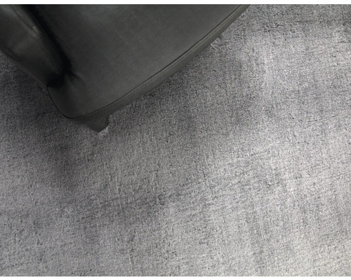 Gros plan d''un tapis gris à côté d''un meuble noir