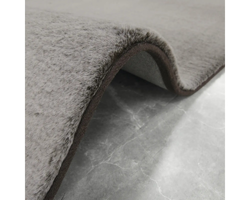 Detailansicht eines grauen Teppichs mit brauner Umrandung