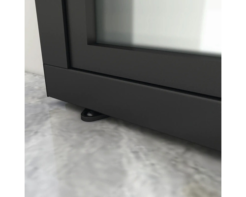 Detailansicht eines schwarzen Kamins mit Stellfüßen auf einem Boden.