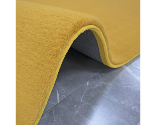 Tapis jaune à poils sur fond gris