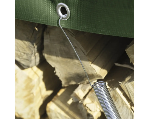 Gros plan d''une bâche fixée à une pile de bois avec un tendeur de bâche