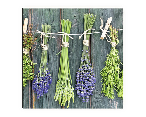 Dekoratives Wandbild mit Kräuterbündeln an einer Schnur vor Holzplanken
