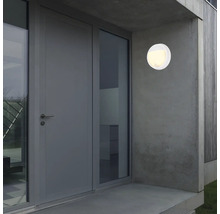 Luminaire extérieur rond blanc sur un mur de maison à côté d''une porte