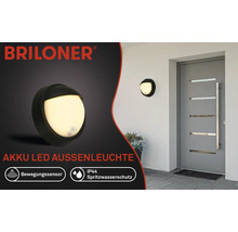 Projecteur d''extérieur LED sur batterie Briloner avec détecteur de mouvement et protection contre les projections d''eau IP44, monté sur un mur de maison.
