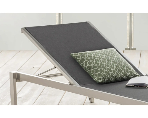 Detailansicht einer Gartenliege mit anthrazitfarbener Liegefläche und einem Kissen mit geometrischem Muster