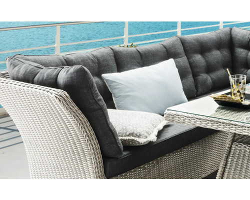 Gros plan d''un salon de jardin en rotin avec des coussins sur une terrasse avec vue sur la mer