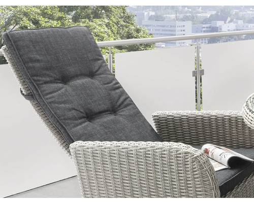 Gros plan d''une chaise longue de jardin grise en rotin avec coussin sur un balcon