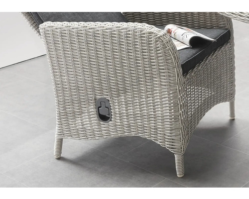 Vue détaillée d''un fauteuil en osier avec un coussin d''assise foncé et un porte-journaux