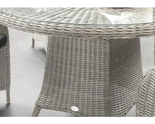 Vue détaillée d''une table de jardin avec plateau en verre et structure en rotin