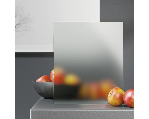 Panneau de verre dépoli devant un mur gris et une table avec des pommes