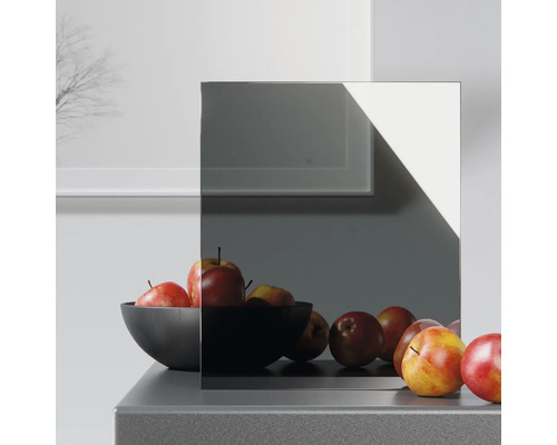 Verre miroir gris sur une commode avec un saladier de pommes