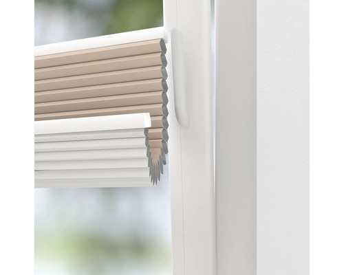 Nahaufnahme einer beigefarbenen und weißen Plissee-Jalousie an einem Fenster
