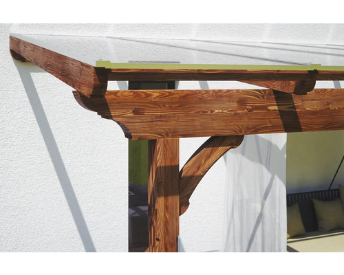 Detail einer Holzpergola mit transparentem Dach zum Anbau an ein Haus