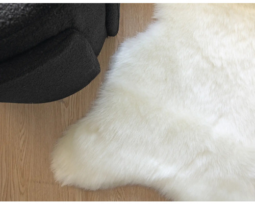 Weißer Teppich aus Kunstfell neben einem Sessel