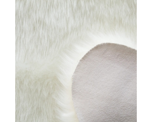 Detailansicht eines weißen Teppichs mit langen Fasern und einer rutschfesten Unterseite