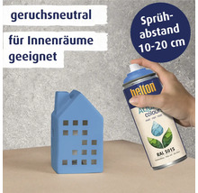 Eine Person sprüht mit einer blauen Farbspraydose ein blaues Hausmodell. Die Dose ist geruchsneutral und für Innenräume geeignet. Der Sprühabstand sollte 10 bis 20 Zentimeter betragen.