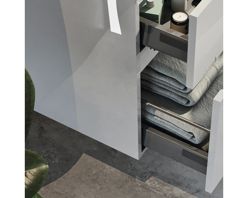 Detailansicht eines Badezimmerschranks mit offenen Schubladen und Handtüchern