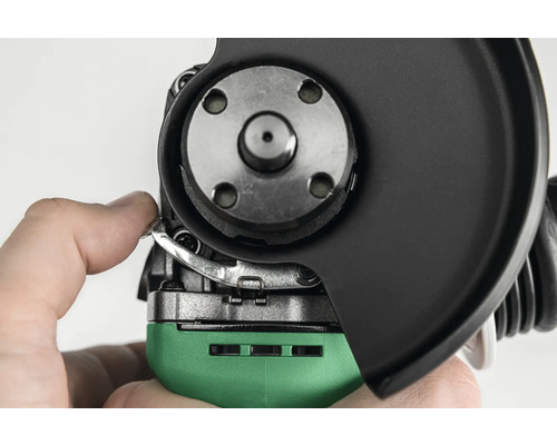 Detailaufnahme eines Winkelschleifers beim Anpassen der Schutzhaube.