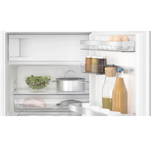 Intérieur d''un réfrigérateur avec des aliments tels que des œufs, de la salade et des boissons